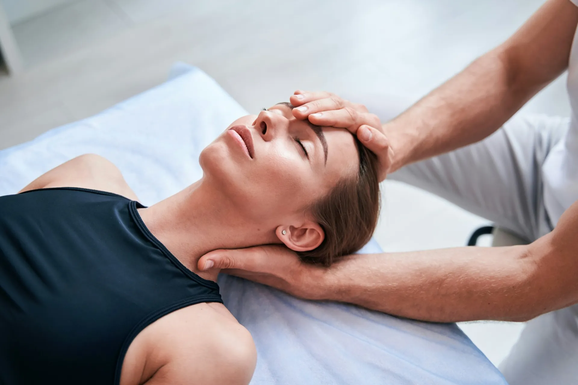 Ostéopathe pratiquant une manipulation cervicale douce sur une patiente